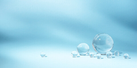Blue background with transparent glass balls. Minimal concept and soft sunlight.