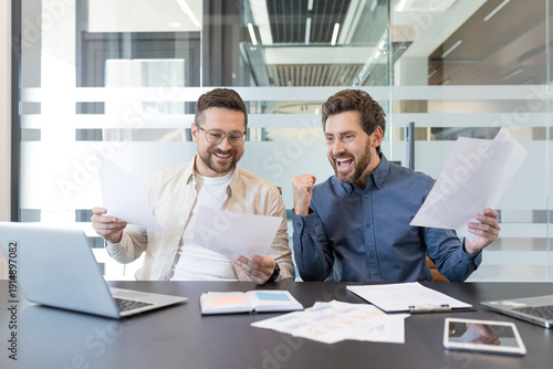 Canvas-taulu Two happy male business partners are celebrating achievement and financial succe