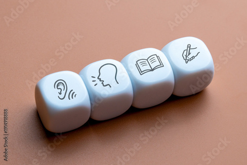 Foto Four white cubes displaying icons for listening, speaking, reading, and writing skills