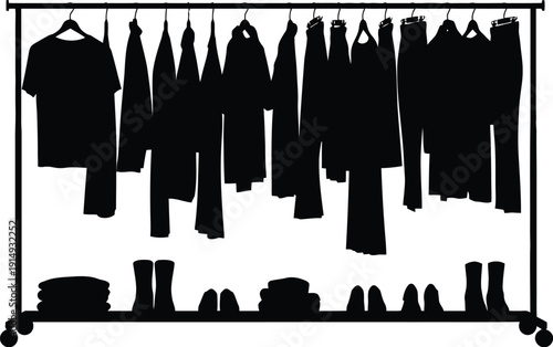 Clothes rack with various garments and folded items a dark silhouette