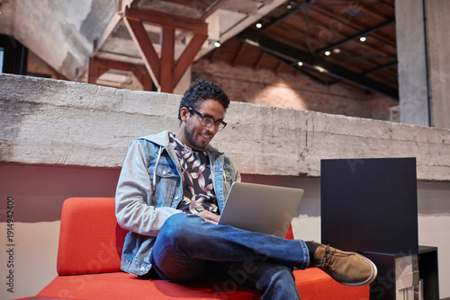 Young man working in creative start-up company, using laptop