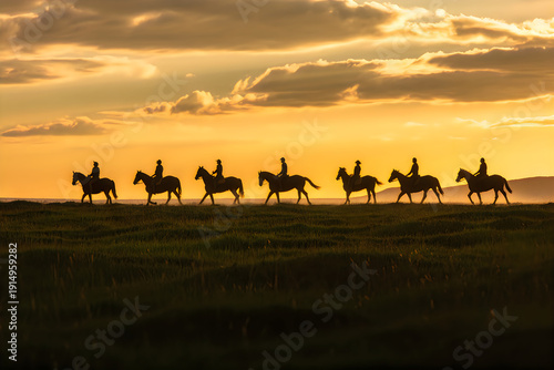 Horseback riders silhouetted against sunset