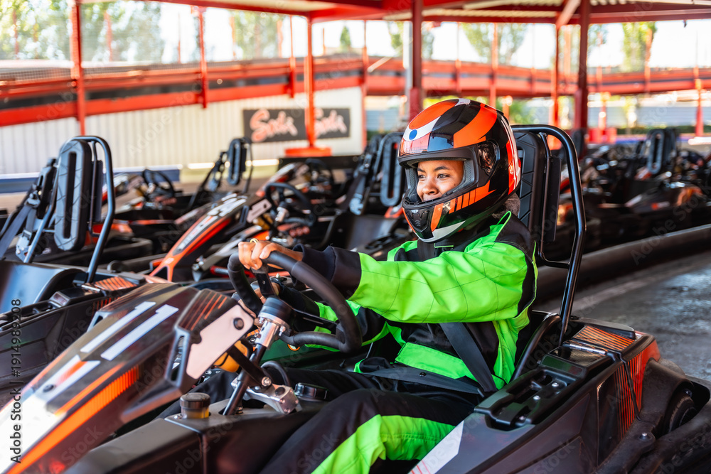 Fototapeta premium Young woman enjoying karting at race track