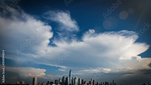 Epic cloudscape above the New York City skyline with One World Trade Center against a bright blue sky