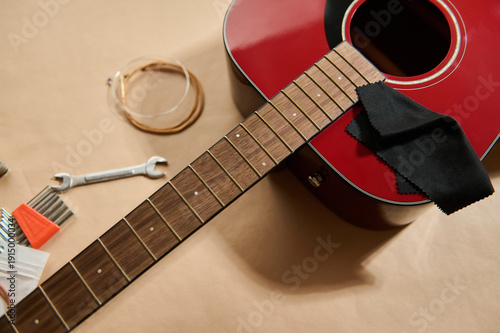 Foto Guitar String Change and Maintenance on Red Acoustic Guitar with Tools