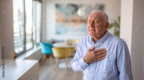 The elderly man clutching his chest in apparent heart pain at home