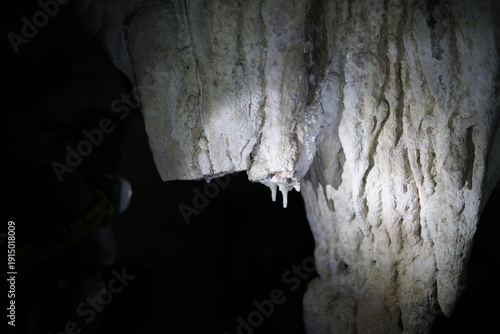 Photos Underground cave with stalactites and stalagmites illuminated by a light source
