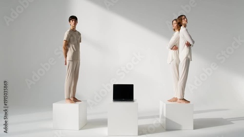 Two women standing on white pedestals in a minimalist studio setting.