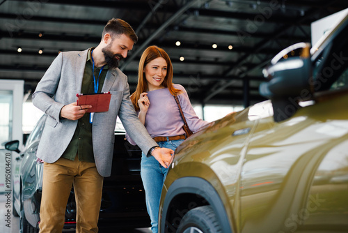 Foto Woman discussing car features with sales consultant at dealership
