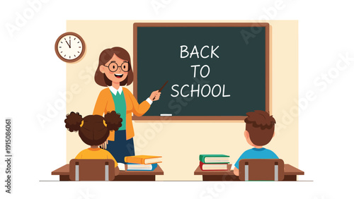Friendly teacher points to the blackboard while students sit at their desks for the first day of the back to school season.