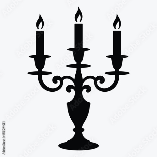 Elegant black candelabra with three lit candles on ornate holder