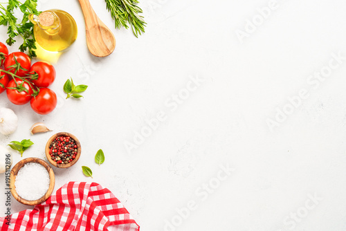 Spices, herbs and vegetables with olive oil on white kitchen table.