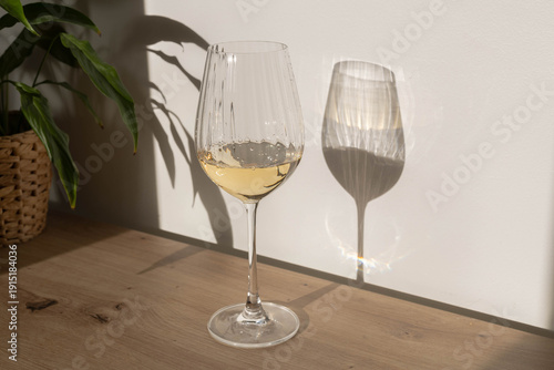 glass of white wine with shadow and sun light