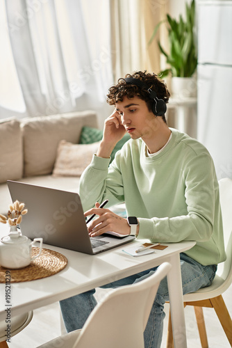 Handsome young man in casual attire working in a modern apartment space
