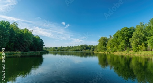 Still reservoir in rural landscape showing pure sky and dense trees