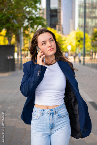 Young woman speaking on phone outdoors in urban setting