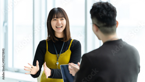 Schilderij op canvas 打ち合わせで会話する女性社員と男性社員, Business colleagues talking during meeting in office