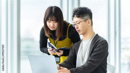 Bild auf Leinwand ノートパソコンを見ながら相談する新人社員と先輩社員, New employee consulting with senior colleague while l