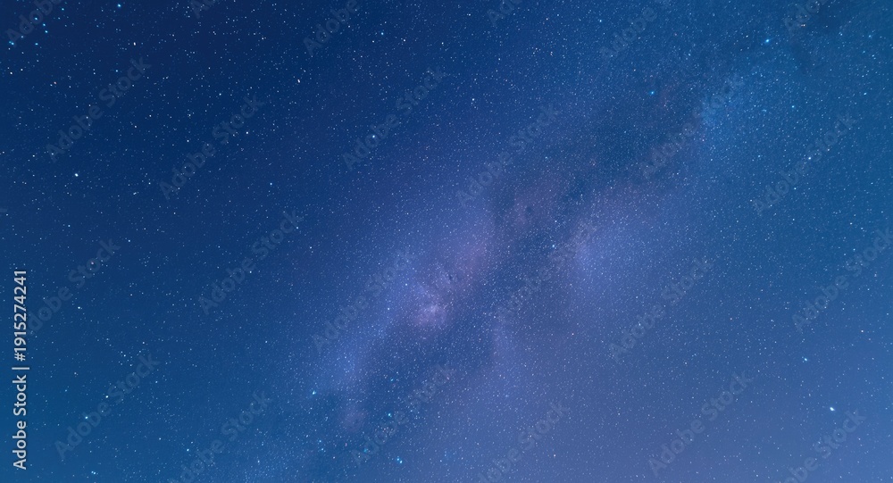 Fototapeta premium A peaceful blue sky above a luminous galaxy twinkling with star clusters