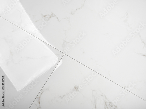 A white marble tiles with gray veining and thin grout lines creating a geometric pattern.