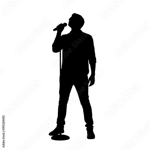 Silhouette of a man singing into a microphone on stage.