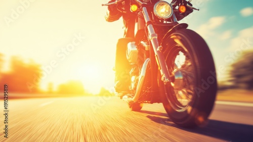 Motorcycle rides down a road at sunset with sunlight shining bright