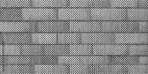 Close up of dark asphalt shingles with a repeating textured pattern