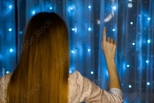 Woman reaching for blue star lights
