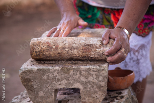 Fotografie Preparing Mexican black recado on a traditional metate in the Yucatan Peninsula
