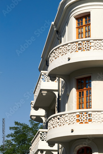 Elegant white classical building with curved balconies and wooden windows