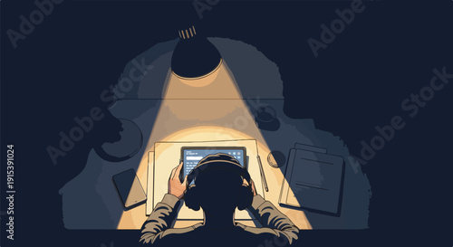 Focused individual working on a tablet with headphones under a desk lamp in a dark room, depicting intense concentration and late-night work.