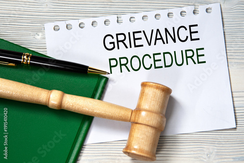 GRIEVANCE PROCEDURE - words in white paper against the background of a green folder and a judge's gavel