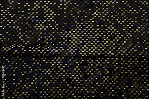 Abstract close up of a dark textured surface with small yellow and blue dots