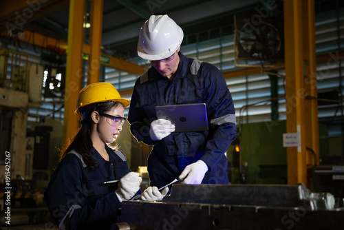 Fotografie Concentrated male engineer and female technician wearing safety hardhat and glov
