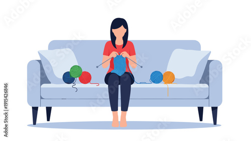 Woman sitting on a blue sofa while knitting with blue yarn and several colorful balls of wool for hobby and relaxation concept.