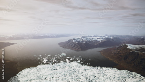 Bild auf Leinwand Vast mountain ranges rise above a serene body of water, creating a breathtaking view of icy terrain blending with calm, reflective surfaces