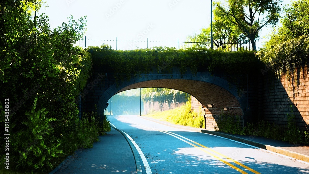 Fototapeta premium A peaceful road curves gently beneath an elegant archway, embraced by vibrant greenery. Sunlight filters through the trees, creating a serene atmosphere in this tranquil setting.