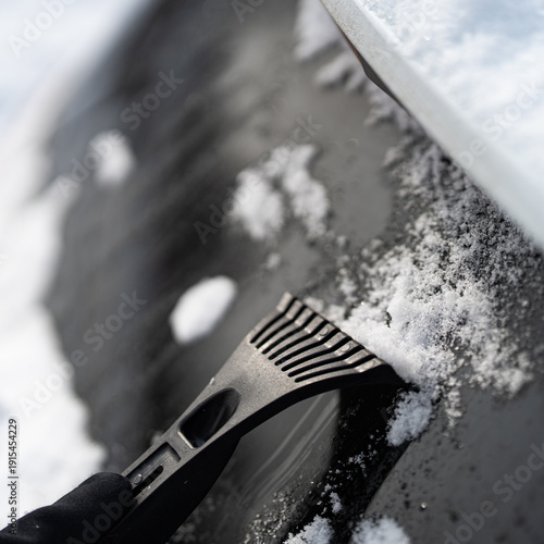 Scraping Ice and Snow from Car Windshield on a Cold Winter Morning