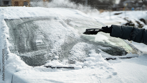 Scraping Ice and Snow from Car Windshield on a Cold Winter Morning