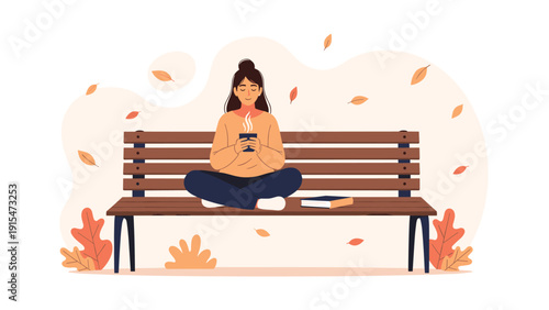 Young woman sitting peacefully cross-legged on a park bench, holding a warm cup of hot beverage amidst gently falling autumn leaves, enjoying the tranquil season.