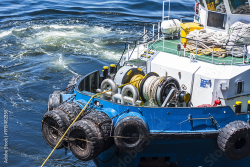 Detailed view of a tugboat’s bow winch and line during ship mooring maneuvers in Mejillones harbor, Chile.