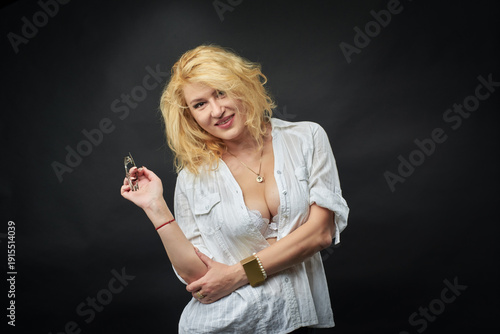 Tableau sur toile A beautiful woman in a white shirt and black skirt stands against a dark background