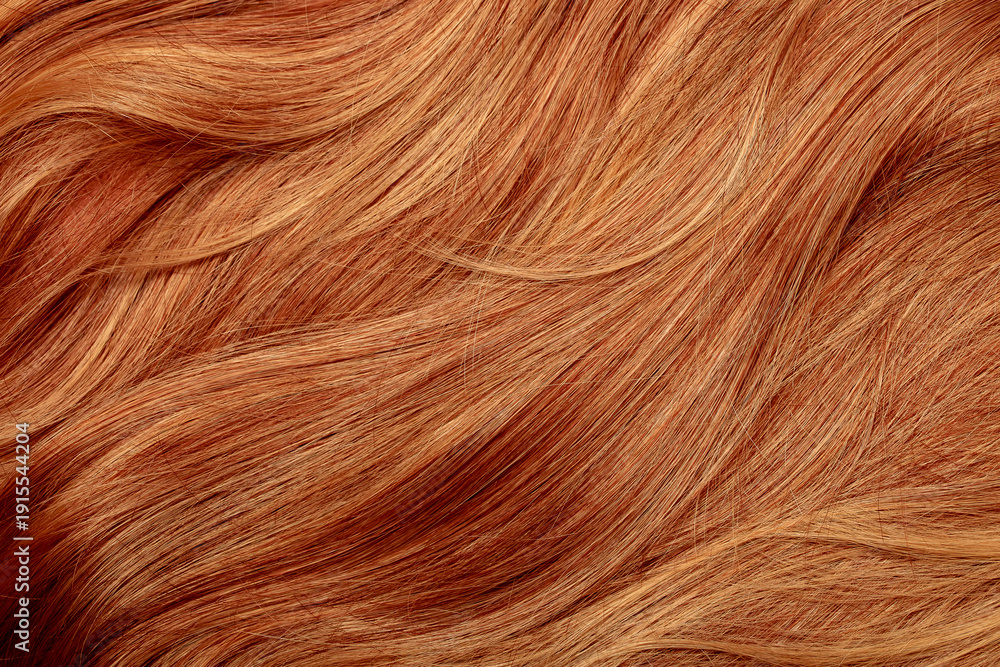 Fototapeta premium Red hair close-up as a background. Women's long orange hair. Beautifully styled wavy shiny curls. Hair coloring bright shades. Hairdressing procedures, extension.