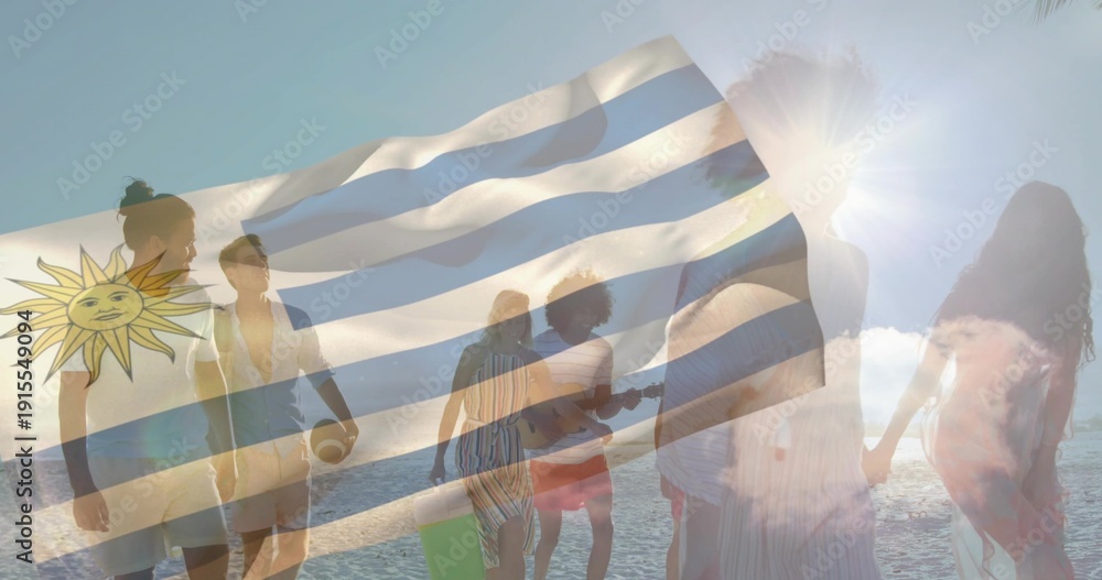 Naklejka premium Walking 8 friends in swimwear on beach at sunset holding guitar ball board Uruguay flag overlay