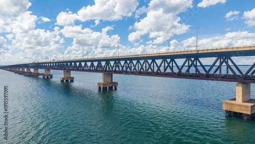 Wallpaper Mural A large steel bridge spans across a body of water under a blue sky with white clouds Torontodigital.ca