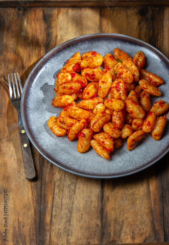 Potato gnocchi with tomato sauce and basil on a gray plate 