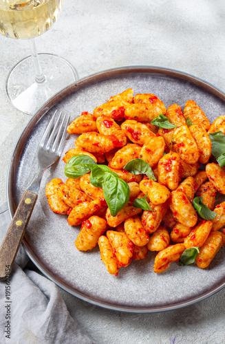 Potato gnocchi with tomato sauce and basil on a gray plate 