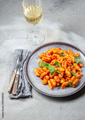 Potato gnocchi with tomato sauce and basil on a gray plate 