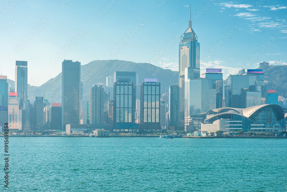Obraz premium Hong Kong skyline along Victoria Harbour with modern skyscrapers and the Hong Kong Convention and Exhibition Centre, China. Global city, financial district, urban development, international business