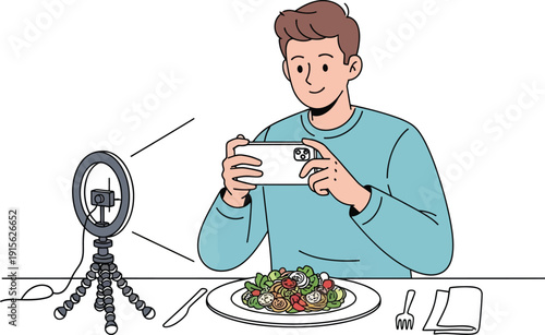 Young man food blogger recording review video with smartphone and ring light equipment while eating fresh salad at home